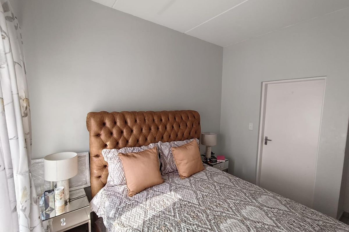 A well-maintained bedroom featuring neutral wall finishes and a standard internal door, providing a clean and comfortable living space.