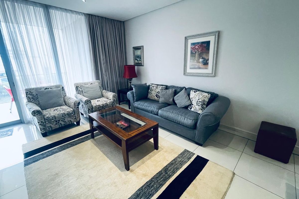 A bright and spacious living room featuring large sliding glass doors that provide ample natural light and access to the balcony area.