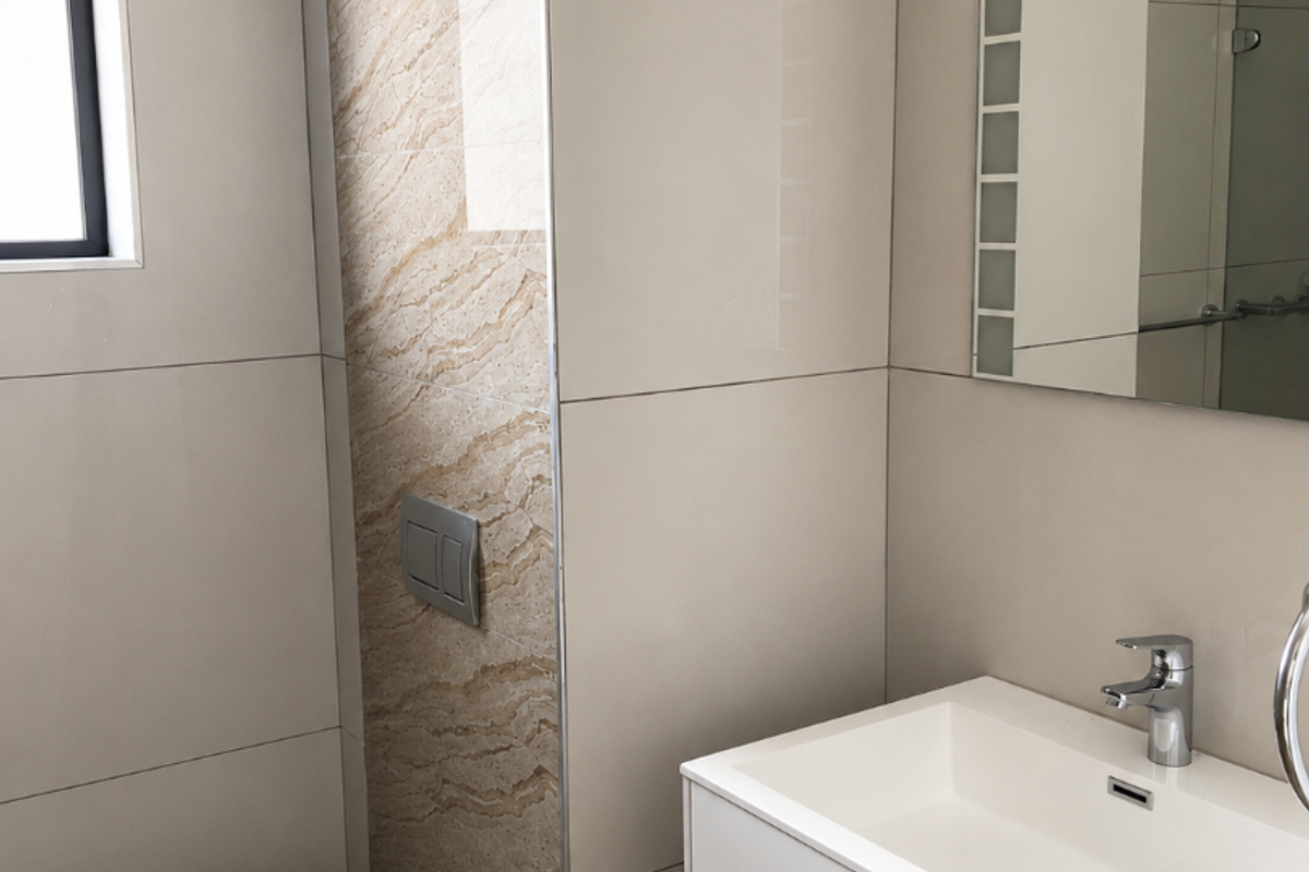 Modern bathroom featuring a wall-mounted toilet, sleek vanity cabinet with integrated basin, and neutral large-format wall tiles.