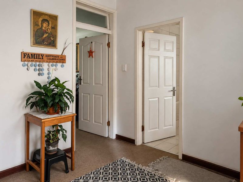 A functional hallway featuring classic panelled interior doors and a transom window, providing access to adjacent rooms within the apartment.