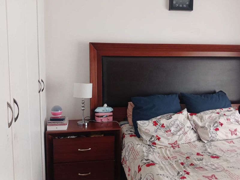 A bedroom featuring built-in cupboards and a dark wood headboard.