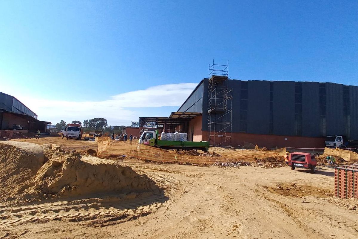 Wide view of an industrial property under construction, featuring large steel-framed warehouse structures and ongoing site development.