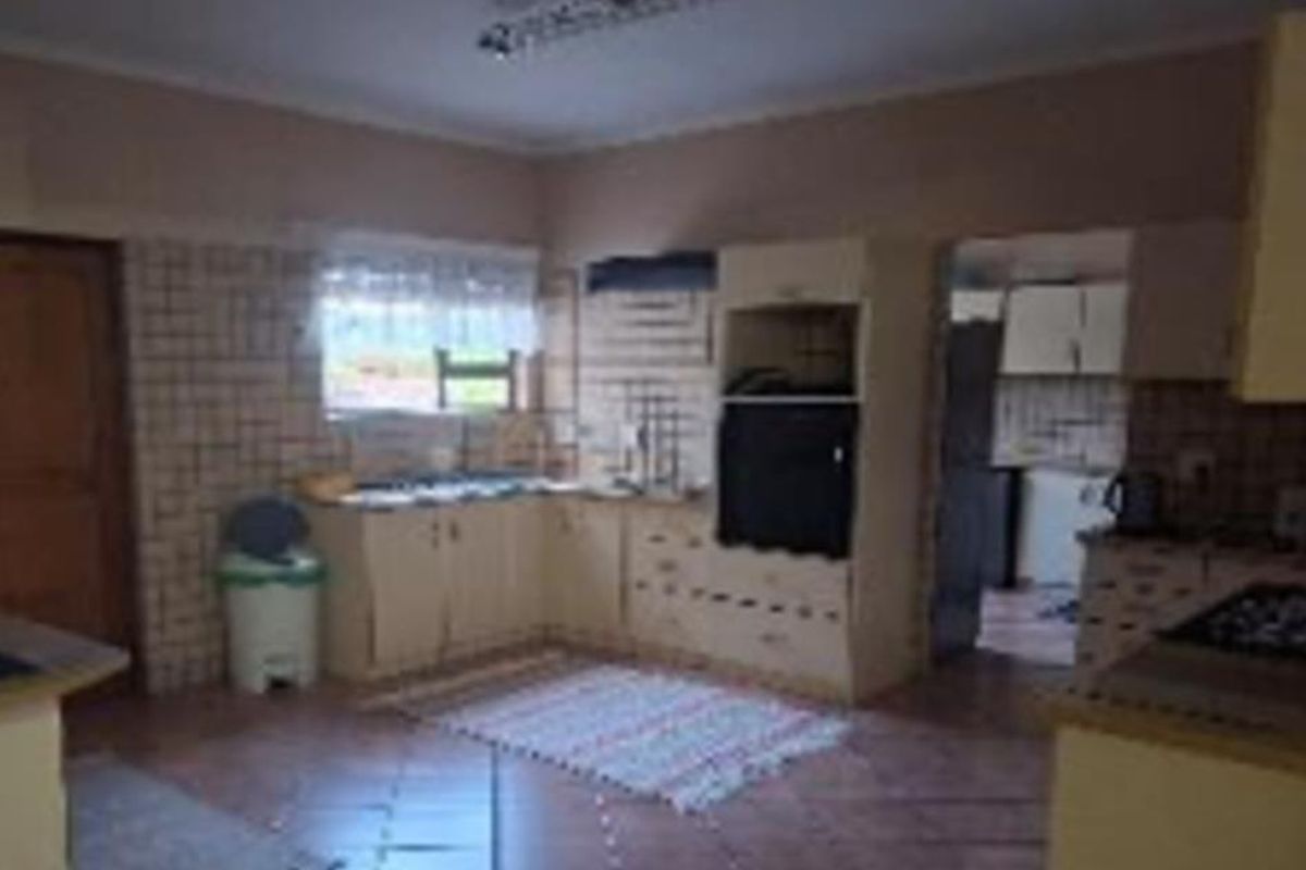 A dated kitchen featuring built-in cabinetry, tiled backsplash, and tiled flooring, offering significant potential for modernization and renovation.