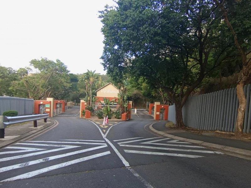 The entrance to the Westwood complex featuring a secure gatehouse, perimeter fencing, and well-maintained access roads.