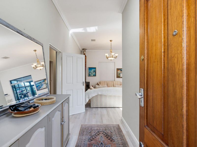 Welcoming entrance hall featuring timber front door, light laminate flooring, and decorative cornice, leading into the main living area.