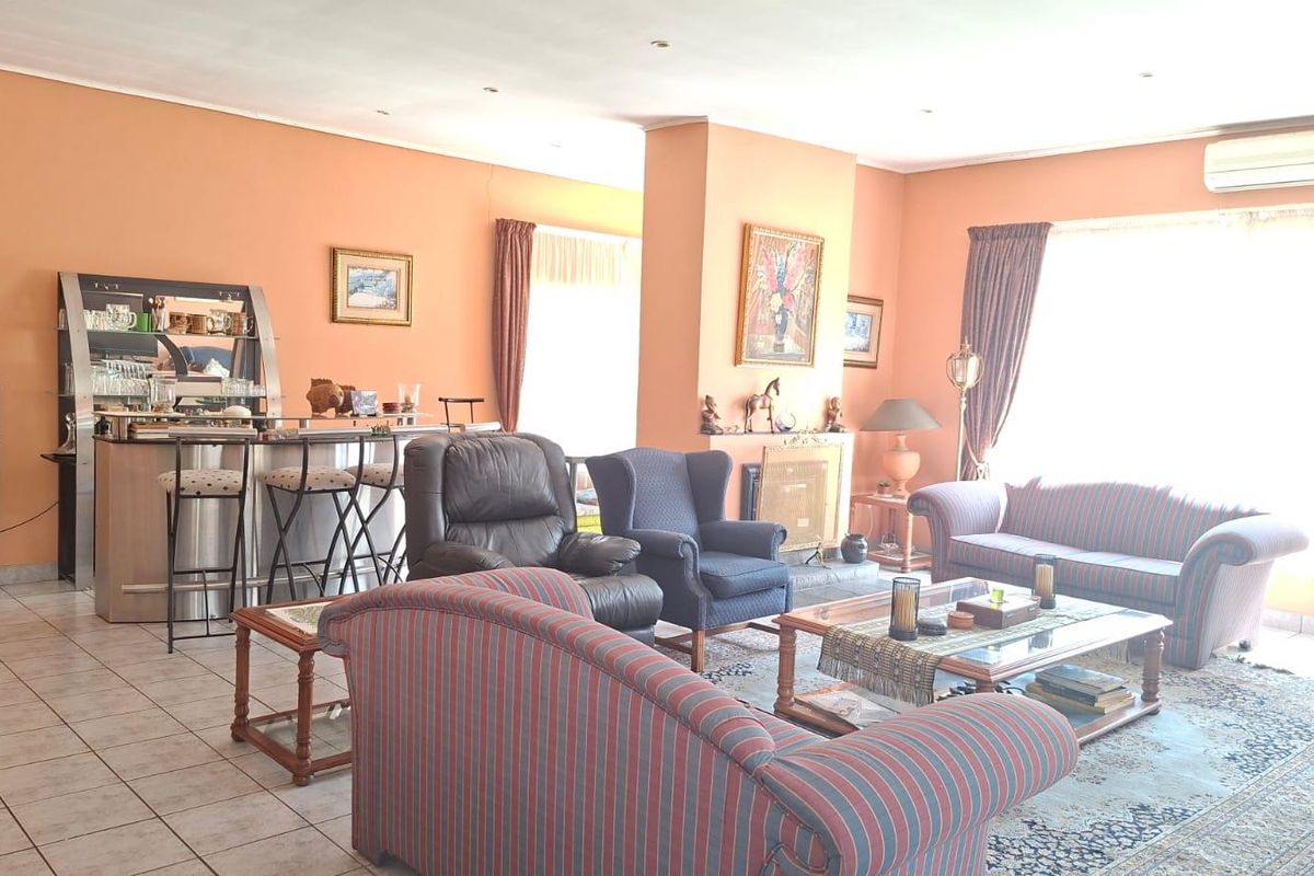 Spacious living area featuring tiled flooring, a built-in fireplace, and a wall-mounted air conditioning unit, offering a comfortable and functional layout.