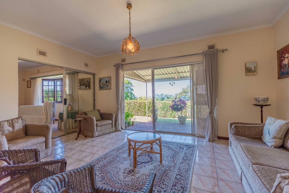 Spacious living room featuring large sliding glass doors that open onto a covered patio, providing seamless indoor-outdoor flow and natural light.