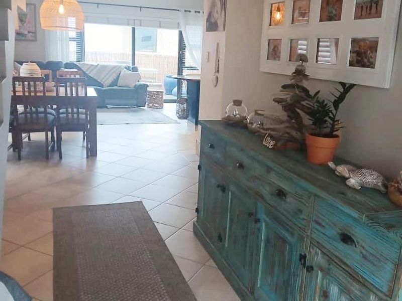 Open plan living and dining area featuring ceramic floor tiles, a staircase, and sliding glass doors leading to an outdoor space.