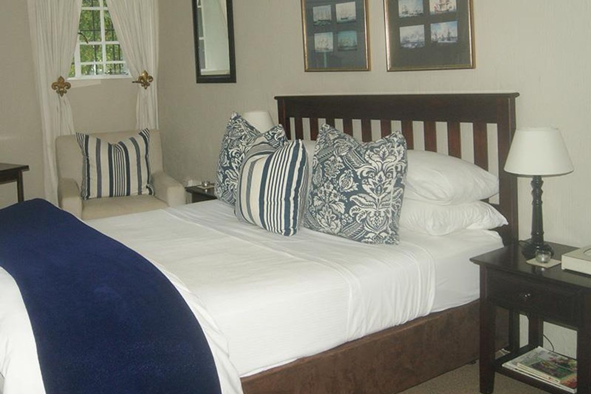 A cozy bedroom featuring a window with security bars and neutral wall finishes.