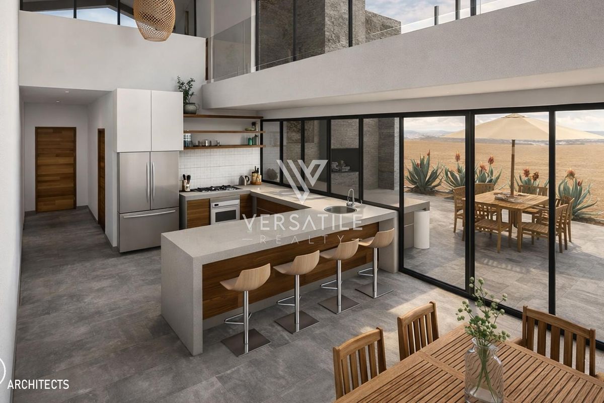 Modern open-plan kitchen featuring a central island, sleek cabinetry, and expansive glass sliding doors opening to an outdoor patio area.