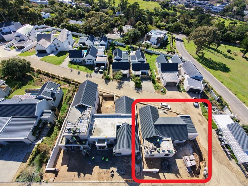 Aerial view of a residential property under construction, highlighting the roof structure and surrounding site development within a suburban estate.