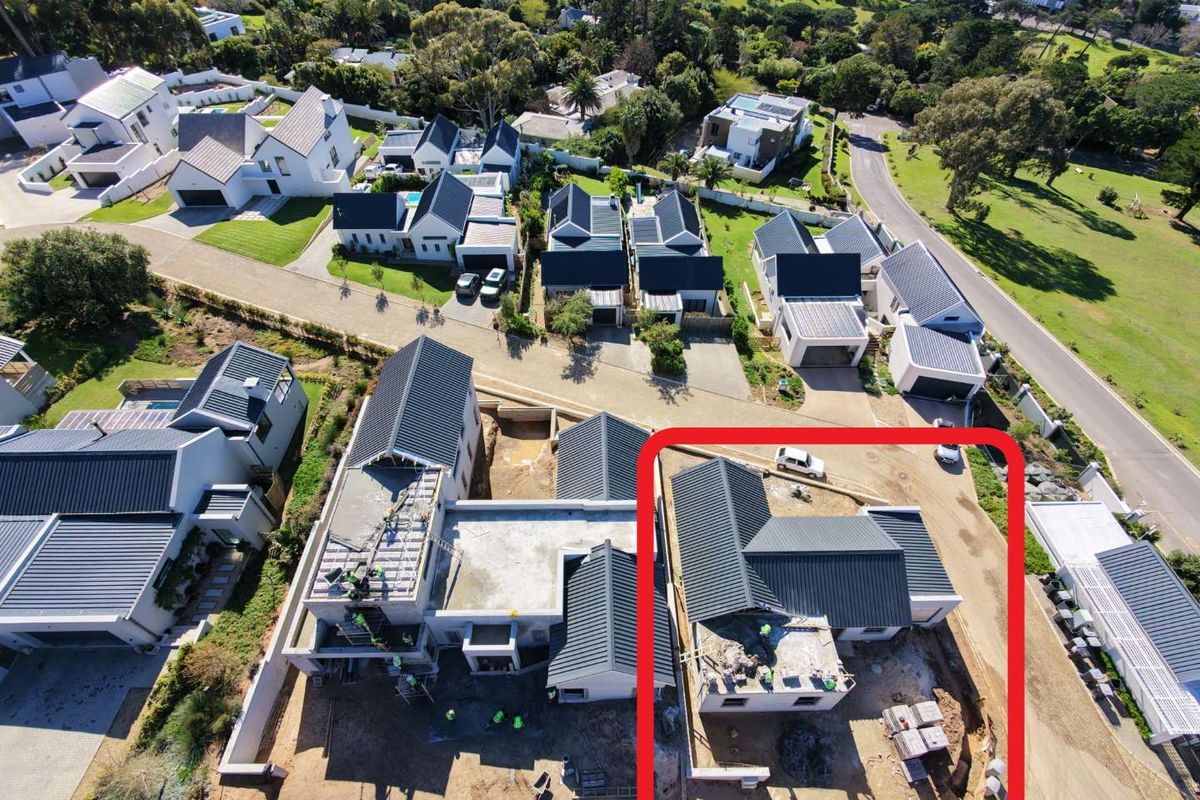 Aerial view of a residential property under construction, highlighting the roof structure and surrounding site development within a suburban estate.