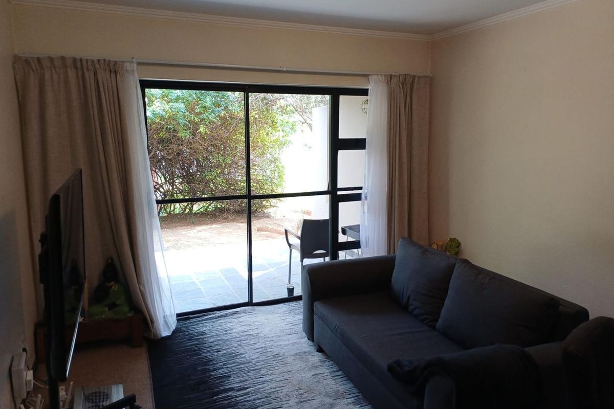A living room featuring a large sliding glass door that provides natural light and direct access to an outdoor patio area.