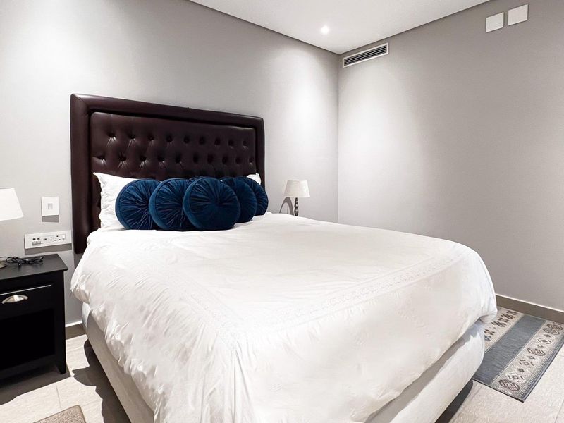 A well-maintained bedroom featuring neutral walls, tiled flooring, recessed lighting, and integrated ducted air conditioning.