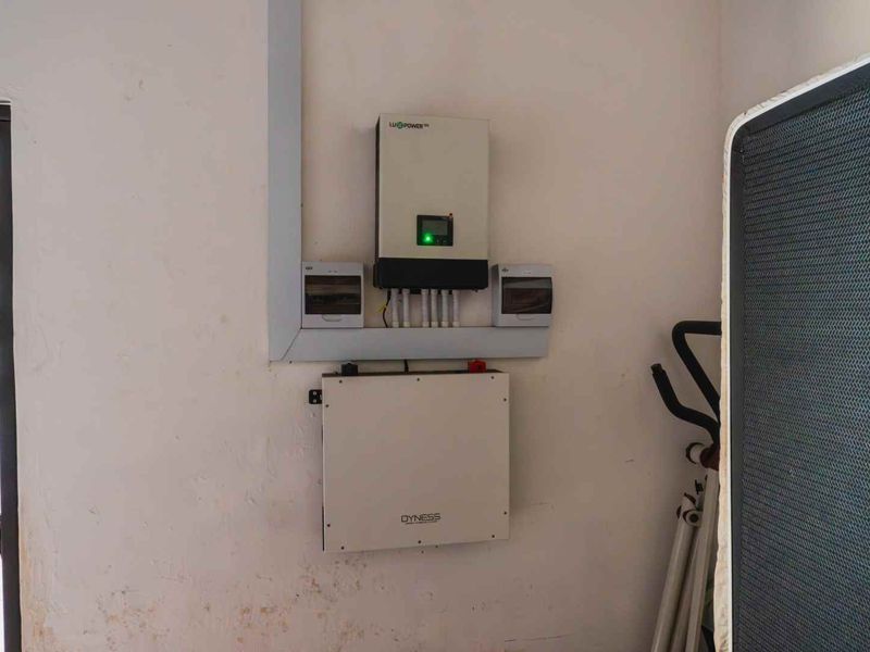 Utility area featuring a wall-mounted solar inverter and battery storage system with integrated electrical distribution components.