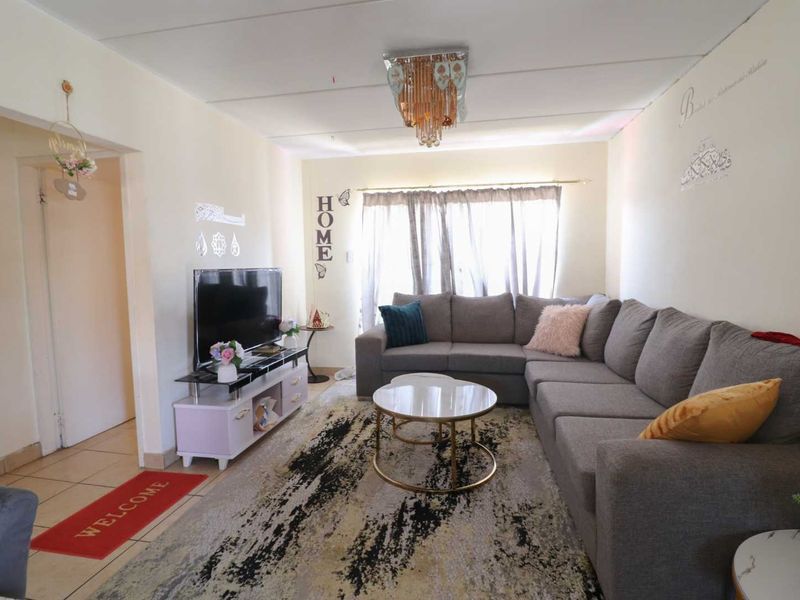 A comfortable living room featuring tiled flooring and a central ceiling light fixture, providing a functional and inviting space for relaxation.