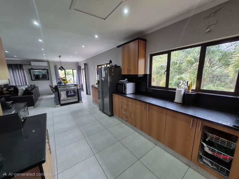 Open-plan kitchen and living area featuring wood-finish cabinetry, dark countertops, tiled floors, and recessed lighting, with visible plaster cracking near the ceiling.