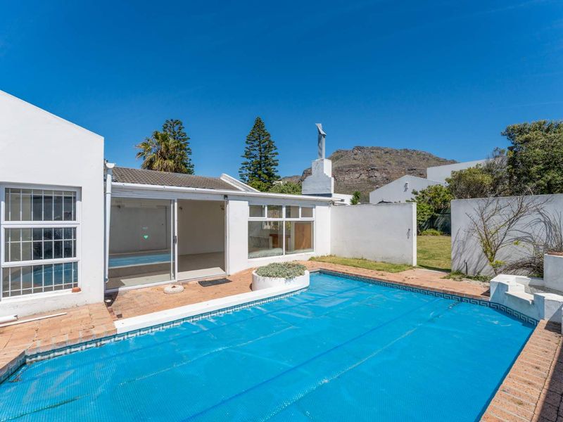 Outdoor pool area featuring a swimming pool with cover, brick paving, and direct access to the home through sliding glass doors.