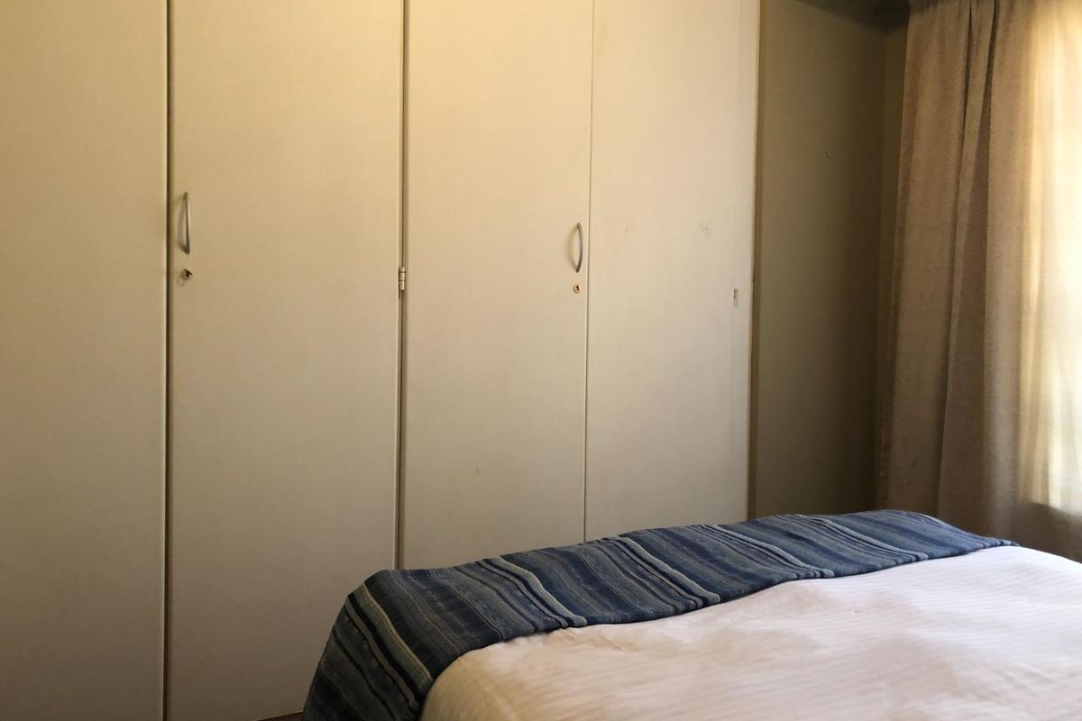 A bedroom featuring functional built-in cupboards providing ample storage space.