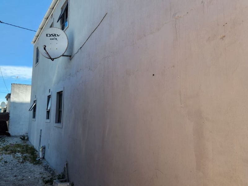 Side elevation of the property showing exterior wall finish, satellite dish installation, and window placements.