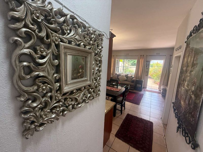An open-plan living and dining area featuring tiled flooring and direct access to the rear garden through a sliding glass door.