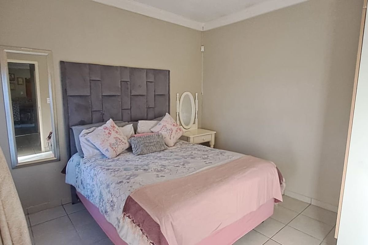 A functional bedroom featuring tiled flooring, a built-in wardrobe, and coved ceiling detailing.