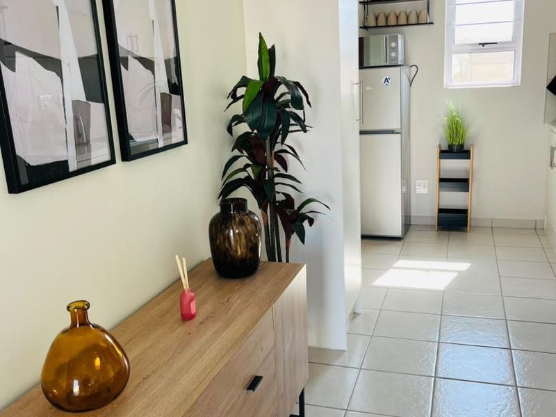 A bright kitchen area featuring neutral tiled flooring, a window for natural light, and clean wall finishes.
