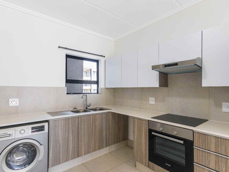 Modern kitchen featuring sleek wood-grain cabinetry, stone countertops, integrated Bosch oven and hob, extractor fan, and a stainless steel sink.