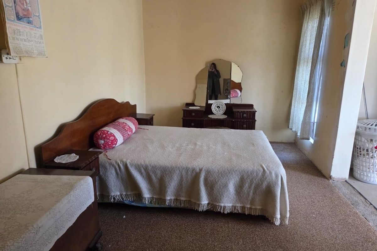 A bedroom featuring carpeted flooring and neutral wall finishes, offering a blank canvas for potential modernization and interior updates.