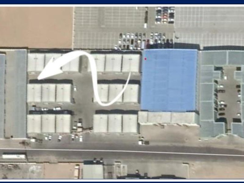 Aerial view of an industrial warehouse complex featuring multiple storage units, metal roofing, and paved parking areas.