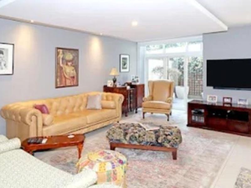 Spacious living room featuring a recessed ceiling with downlights and large sliding glass doors providing natural light and access to the outdoor area.