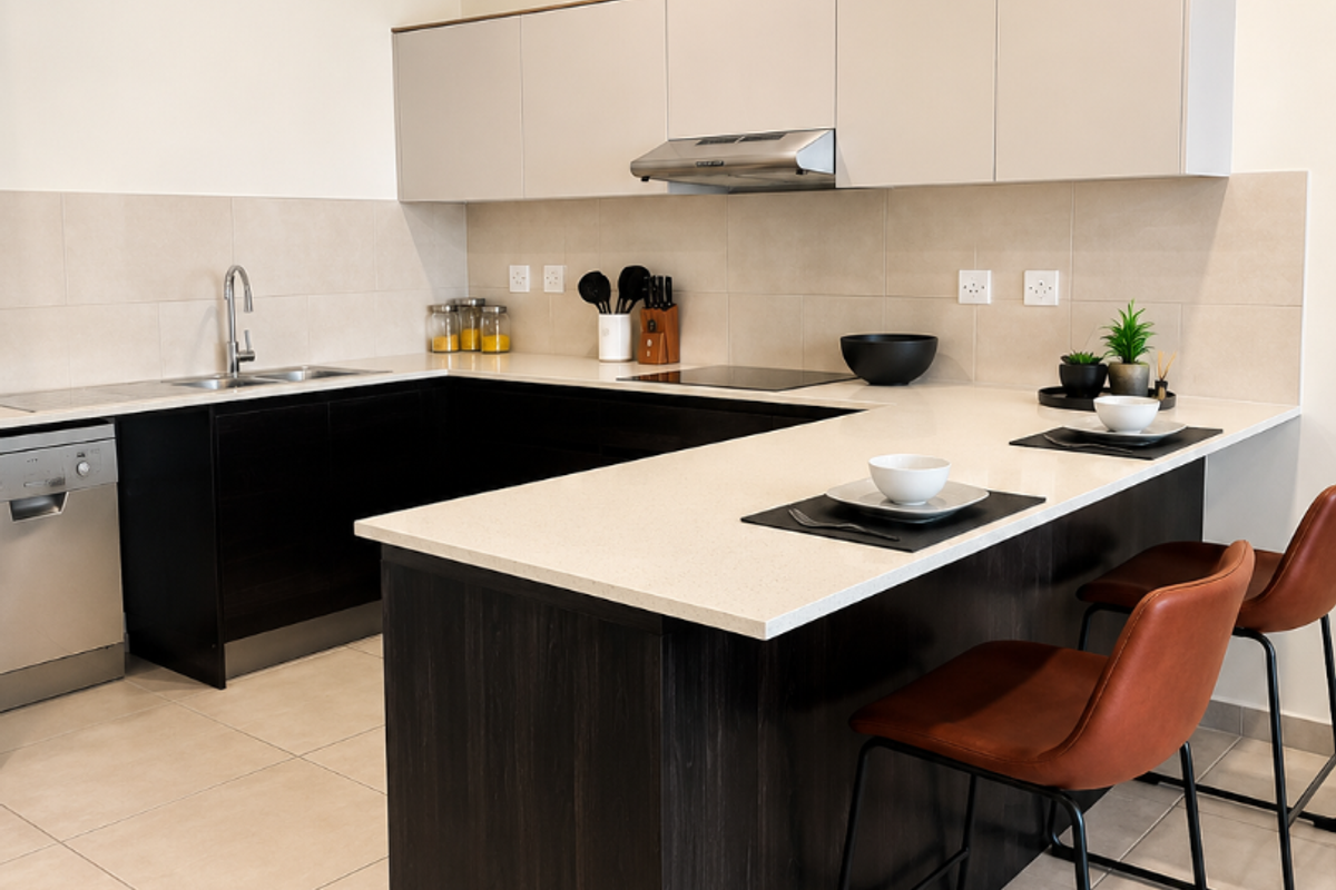 Modern kitchen featuring dark wood cabinetry, light stone countertops, integrated appliances, and a breakfast bar island with tiled flooring.