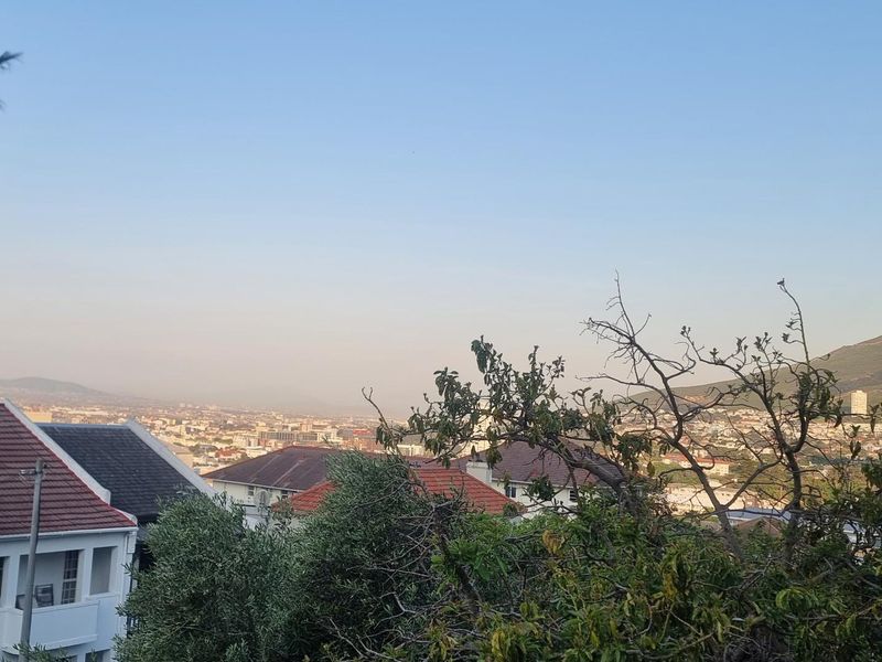 A scenic elevated view overlooking the surrounding city landscape with a prominent mountain backdrop.