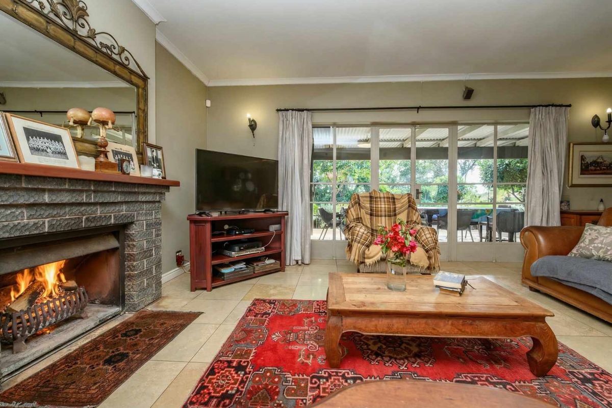 Cozy living room featuring a brick fireplace, tiled flooring, and large glass sliding doors providing natural light and access to the outdoor patio area.