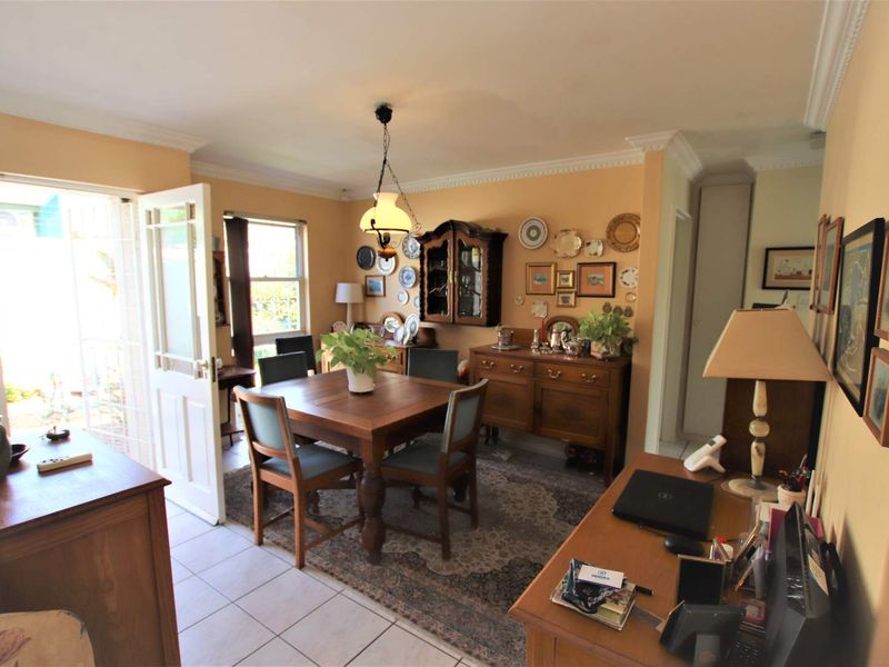 A dining room featuring tiled flooring, crown molding, and a glass-paneled door providing direct access to the outdoor area.