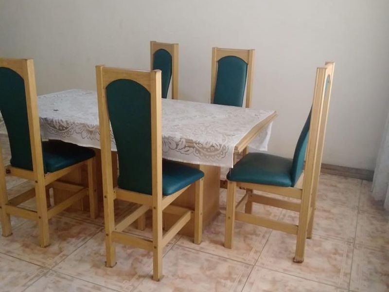 A dining area featuring ceramic floor tiles, providing a functional space for meals.