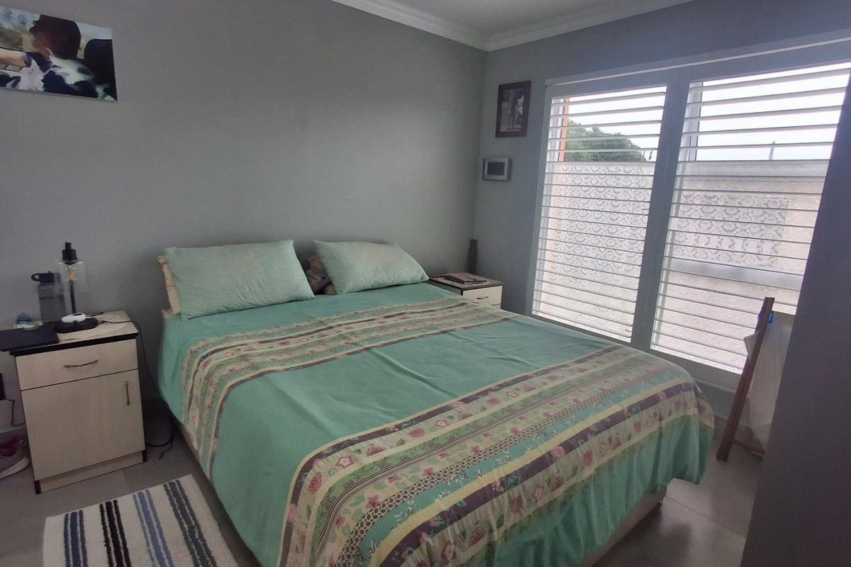A bedroom featuring tiled flooring, coved ceiling cornices, and horizontal window blinds providing natural light.