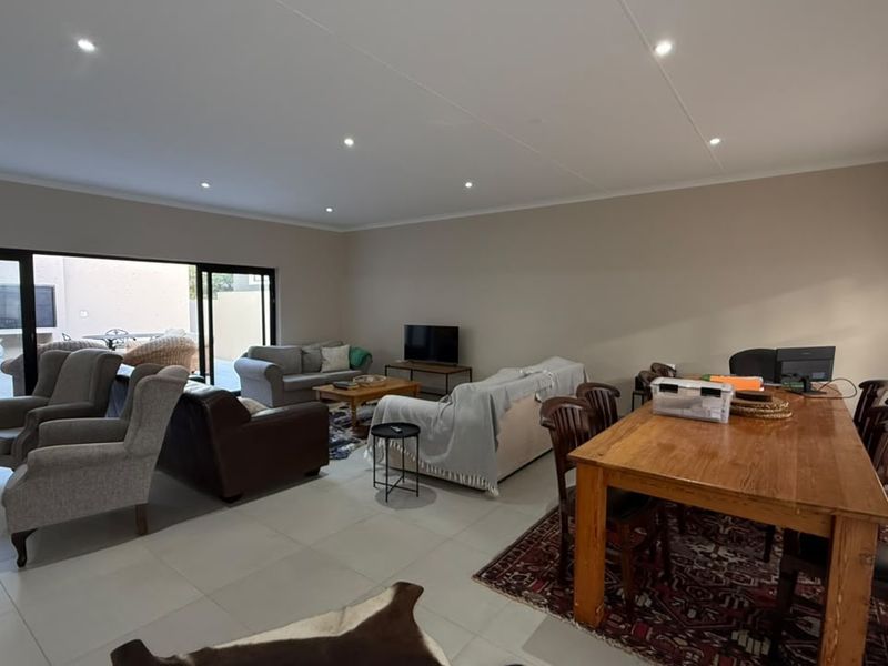 Spacious open-plan living and dining area featuring large sliding glass doors that provide seamless access to the outdoor patio.