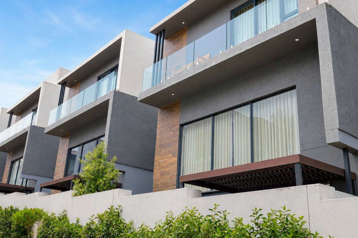 Modern multi-story cluster units featuring contemporary architectural design, glass balustrades, timber-look cladding, and private balconies.