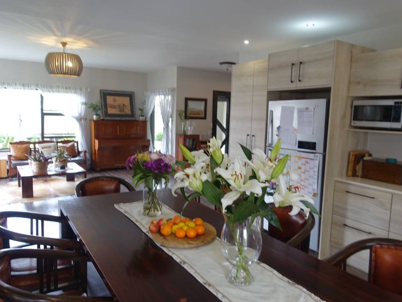 Spacious open-plan living and dining area featuring modern light wood cabinetry, recessed lighting, and a seamless flow between the kitchen and lounge space.