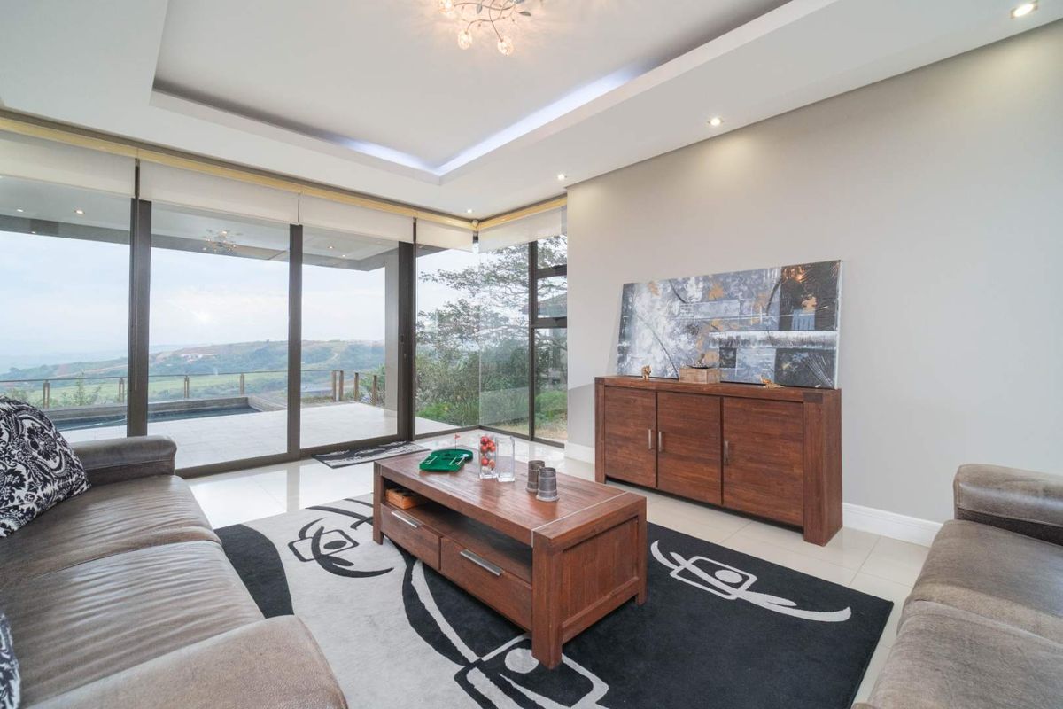 Modern living room featuring large floor-to-ceiling glass sliding doors that provide expansive views and access to the outdoor patio area.