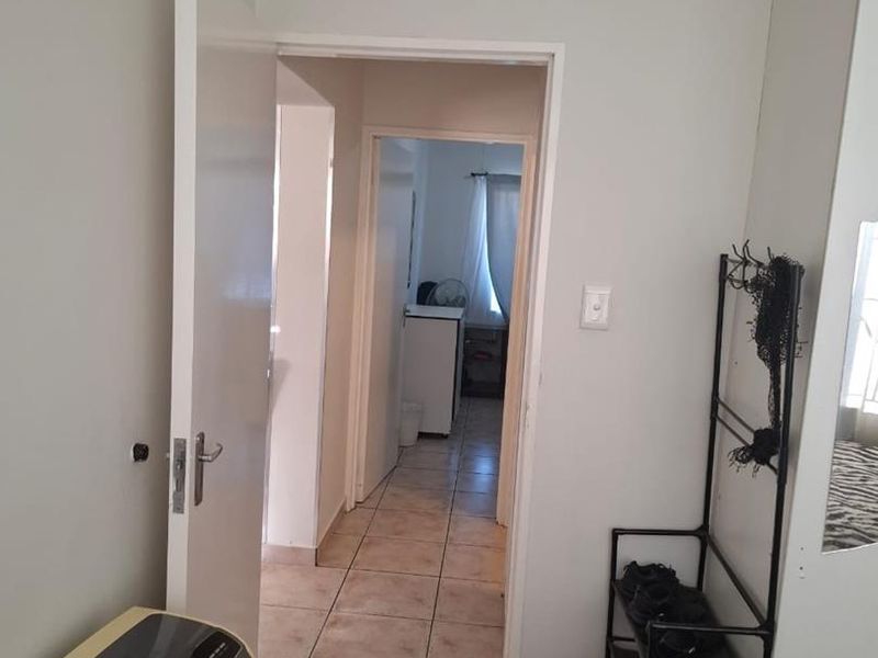 A functional hallway featuring tiled flooring and access to adjacent rooms, providing a clear transition space within the apartment.