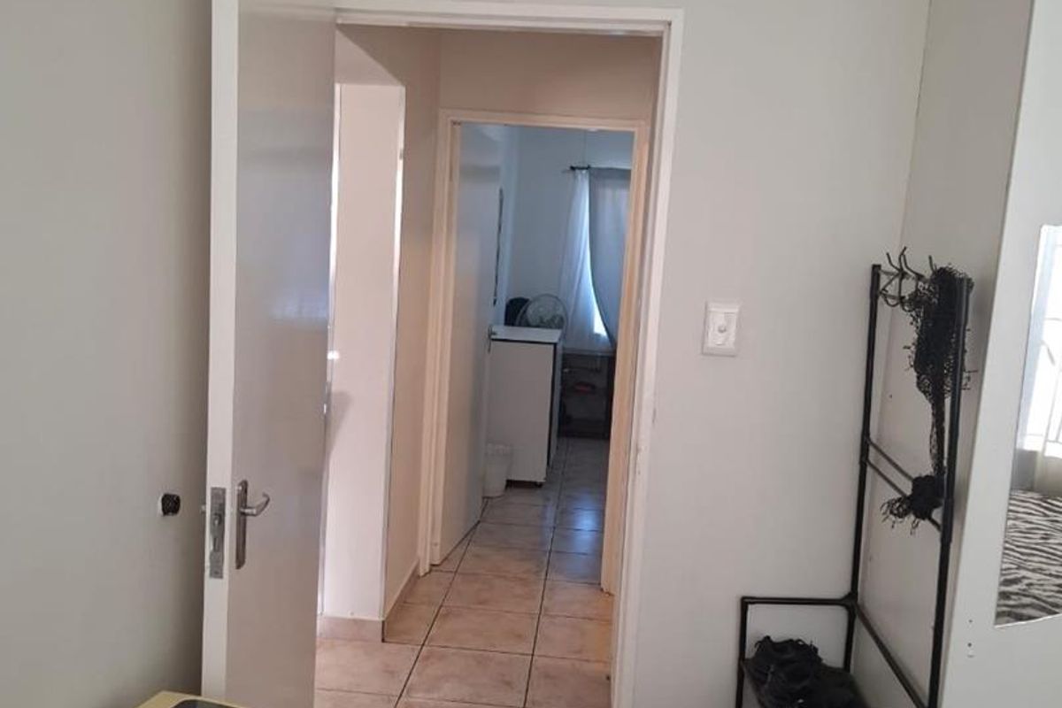 A functional hallway featuring tiled flooring and access to adjacent rooms, providing a clear transition space within the apartment.