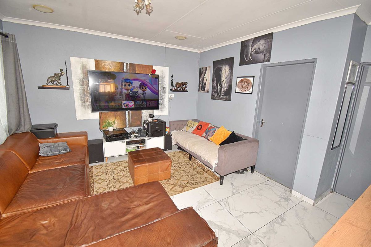 A living room featuring tiled flooring and neutral wall finishes, providing a functional space for relaxation and entertainment.