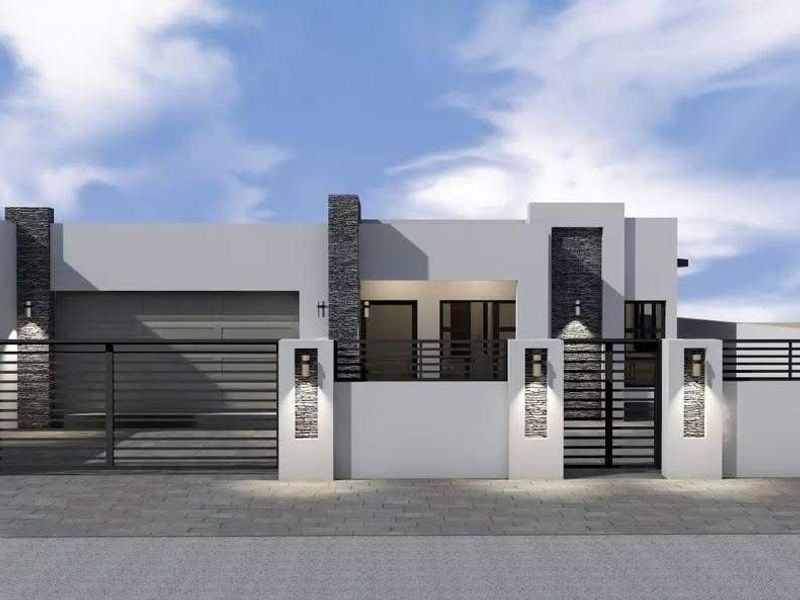 A modern residential facade featuring clean lines, stone cladding accents, integrated wall lighting, and a secure gated entrance with a private garage.