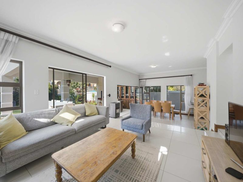 Spacious open-plan living and dining area featuring large sliding glass doors that provide seamless access to the outdoor patio and garden.