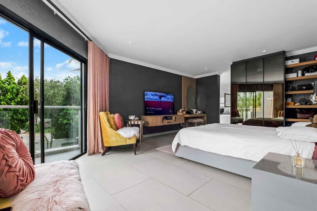 Spacious bedroom featuring large sliding glass doors leading to a private balcony, built-in cabinetry, and modern tiled flooring.