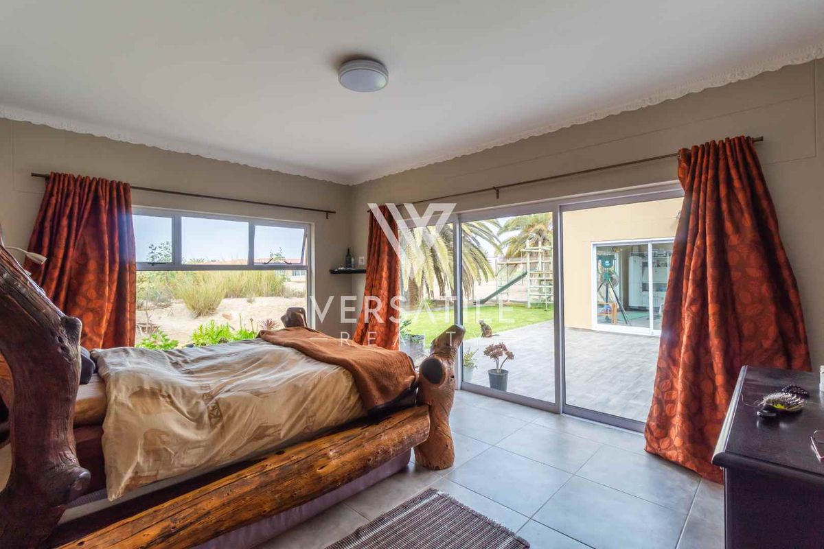 Spacious bedroom featuring large sliding glass doors that provide direct access to the outdoor patio and garden area.