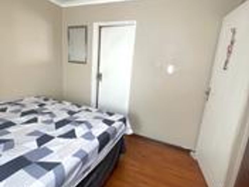 A standard bedroom featuring laminate flooring and neutral wall finishes, providing a functional and comfortable living space.