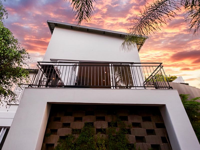 Rear elevation of the property featuring a private balcony with metal railings and a decorative breeze block wall detail.